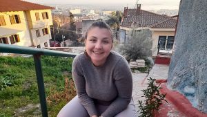 Maria Eleni Pouliezou fick en snilleblixt. I stället för att gå omkring och inte gilla läget tar hon sin universitetsutbildning i bagaget och flyttar från Grekland till Finland i sommar. Maria Eleni sitter leende med håret i hästsvans på en stentrappa med en vy av hemstaden Thessaloniki i bakgrunden.