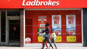 Ihmisiä kävelee vedonlyöntitoimiston ohi.