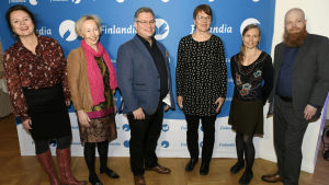 Sex Finlandianominerade författare poserar för pressen framför Finlandiaprisets reklamvägg.