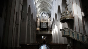 Spökar det i Åbo domkyrka? Insidan av Åbo domkyrka med vy över predikstolen och orgeln och kyrkbänkarna.