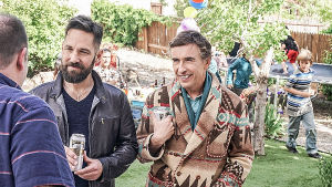 Paul Ruddin ja Steve Cooganin hahmot seisovat vierekkäin ja keskustelevat kolmannen miehen kanssa puutarhassa lastenjuhlissa.