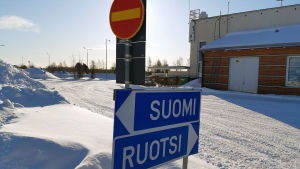 Vid gränsen Torneå-Haparanda pendlar många mellan Sverige och Finland för arbete. Trafikskyltar med texten "Sverige" och "Finland" vid snöig gräns i Torneå