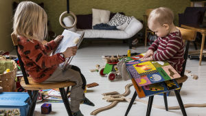 Helsingfors postar bland annat fakturor för dagvård, tandläkarbesök och mycket annan slags vård. Två barn med böcker.