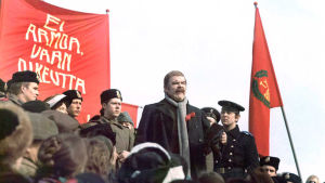 Risto Mäkelä johtaa puhetta torilla elokuvassa Luottamus.