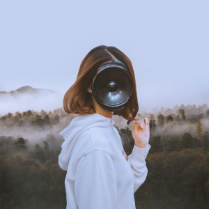 huppariin pukeutunut hahmo, jolla on kasvojen tilalla kaiutin