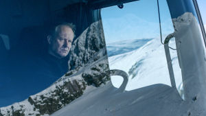 Lumiauramies. Karaktären Nils sitter i hytten på plogbilen och omgivningen spelad i vindrutan.