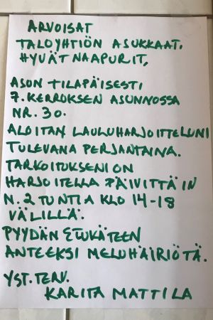 Lappen som Karita Mattila satte upp i höghusets trappa. En lapp, där Karita Mattila ber om ursäkt för oljudet då hon har sångövningar.