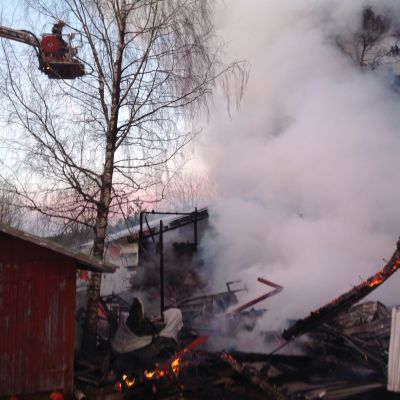 Maantasalle palanut varastorakennus, savuavat rauniot.