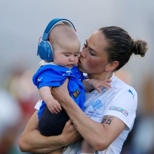 Sara Björk Gunnarsdottir håller sin son i sin famn.
