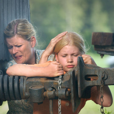 Marjatta Hovi (Maija Junno) ja tyttärensä Ella (Milja Siljamäki) suojautuvat pommilta (2003).