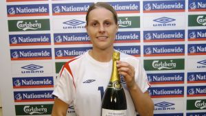 Kelly Smith poserar med en champagneflaska hon fick i egenskap av matchens bästa spelare under en kvalmatch 2006. Då hade hon inte ännu berättat om sina problem. Kelly Smith poserar med en champagneflaska.
