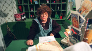 Ritva Valkama Vaapukkalan Olga, Vaapukkalan Puotipostin tomera postimestari Olga P. Postinen (Ritva Valkama) varustautuu joulukiireisiin. Kuvaus pvm : 19960916