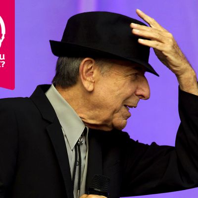 Leonard Cohen håller i sin hatt som är på huvudet.