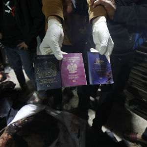 En palestinier visar upp tre utländska pass som ska tillhöra tre av de utländska hjälparbetarna som dödades i en israelisk flygräd på måndagen. 