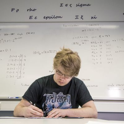 Fysiikan opiskelija tekee koulutehtäviä.