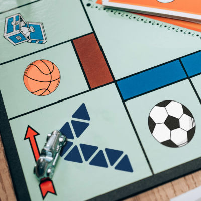 Ett monopolspel med de traditionella symbolerna utbytta till Veikkaus logo, tre bollar och en ishockeyklubba med puck.