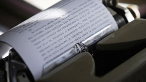 Paperi ja sille kirjoitettua tekstiä mekaanisessa kirjoituskoneessa.