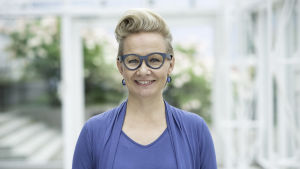 Paulina Ahokas seisoo Tampere-talossa ja hymyilee kameralle.