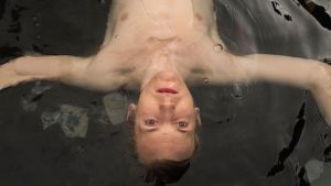 Elliott Crosset Hove spelar den unge Kjeld i Danmarks bidrag Forældre. Den unge Kjeld ligger och flyter i vatten med blicken riktad rakt uppåt mot kameran.