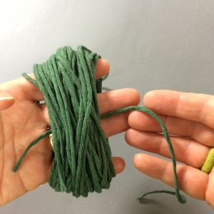 Snurra garnet runt handen och knyt sedan om en gång runt trådarna inne i handflatan och sedan runt allt då du tagit lös garnet från handen. Garn virat unt en hand