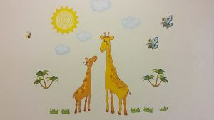 Att berätta saker för varandra ökar ordförrådet och förståelsen. Väggmålning av två giraffer.