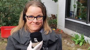 Maria Saaristo på sin uteplats försedd med en egen "coronasäker" bandspelare. Maria Saaristo, författare till romanen "Tomma simbassänger". Utanför sitt hem i Hagalund våren 2020..