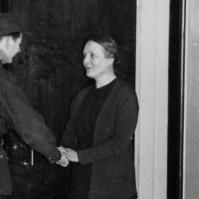 Matti Alanko lähdössä sotaan kotoaan taiteilijakoti Lallukasta, Apollonkatu 13. Martta-äiti hyvästelee poikaansa kotiovella.