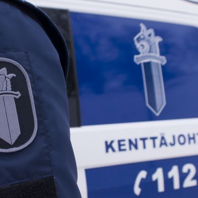 Poliisin hihamerkki ja poliisiauto