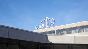 Cumulus-patienthotellet i Helsingfors kan bli ett alternativ för nyblivna mammor. Sjundeå bad hotellbyggnad. taket med cumulus logo syns.