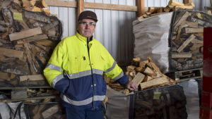 Rolf Rehn har sålt ved i knappa tjugo år. En person som lutar mot en säck med vedklabbar