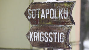 Krigsstigen ska få nya informationsskyltar. en brun skylt som det står krigsstig på