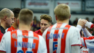 Timo Oksanen (till vänster) tränar BK-46:s herrlag i handbollens FM-liga tillsammans med Andreas Rönnberg (mitten). Andreas Rönnberg omringad av bk-spelare.