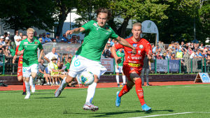EIF:s Ville Sevón skjuter iväg bollen med JAros JOni Remesaho i bakhasorna. Ville Sevón (EIF) med bollen skuggad av Joni Remesaho (Jaro)