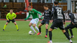 Inbytta EIF-spelaren Simon Lindholm omringas av flera KPV-spelare. Domaren Kalle Mäkinen till vänster på bilden. EIF:S Simon Lindhom omringad av KPV-spelare.