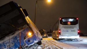 Snöovädrat orsakade många trafikolyckor på tisdagen. En buss ligger på sned i snödrivan invid en väg.