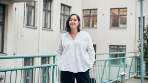 Inka Hietala som jobbade som producent för serien trivdes i skolmiljön de byggde upp. En kvinna står framför ett hus och ler.