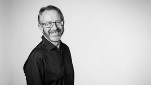 Rolf Zale forskar och undervisar på Umeå universitet. porträtt av rolf zale. han ler och bär glasögon och har en mörk tröja på sig. bilden är svartvit.