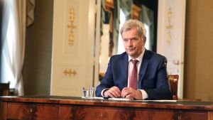 President Sauli Niinistö hade ett telefonmöte med Rysslands president Vladimir Putin på tisdagen. Bilden är en arkivbild från januari 2021. President Sauli Niinistö sitter vid ett skrivbord av trä.Han har kostym och slips på sig.