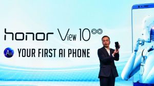 Zhao Ming, VD för Honor, visar en Honortelefon för publik i Indonesien i mars 2018. En man visar upp en mobiltelefon framför en ljud bakgrund.