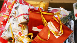 Mjuka klappar var en besvikelse för skribenten som ung Närbild på julklappar inpaketerade i rött papper och i ljust papper med tomtar på.