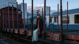Nightbirds sound inspireras av bluesen och dess berättelser och liv Artisten Nightbird sitter på en tågvagn, ser in i kameran, i bakgrunden skymning och glashus.