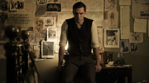 Mitt arbetsbord, mitt rike. Nicholas Hoult spelar huvudrollen som Tolkien. Tolkien står lutad mot sitt skrivbord.