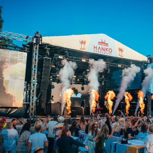 Festival vid vattnet i Hangö. Pyroteknik på scen och glada människor i publiken.