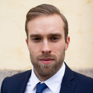 I våras märkte Jere Reijonen av coronapandemins effekter på hyresbostadsmarknaden då studenter sade upp sina lägenheter och lämnade Åbo tidigare än de brukar under våren. En ansiktsbild på en ung brunhårig man som är klädd i kostym.