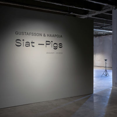 Siat-Pigs -näyttelyn tunnus Seinäjoen taidehallin tyhjässä aulassa.