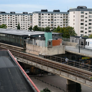 Bild på höghus och en tunnelbana som kommer åkandes.