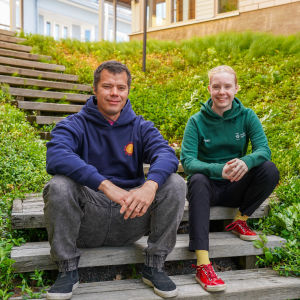Två personer sitter i en trappa, de heter Sebastian Berg och Agnes Kvarnström.