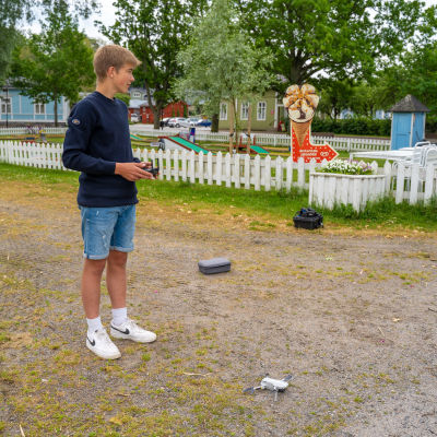 Bild av Jonah Svenskberg och en drönare som står på marken. 