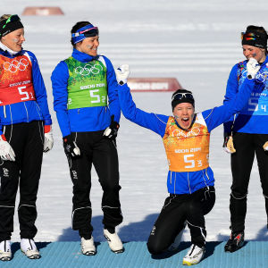 Anne Kyllönen (vas.) Aino-Kaisa Saarinen (toinen vas.) ja Krista Pärmäkoski (oik.) seurasivat vierestä, kun Kerttu Niskanen (toinen oik.) hassutteli palkintopallilla Sothin olympialaisissa 2014.