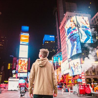 En ung man stirrar på reklamerna på Times Square